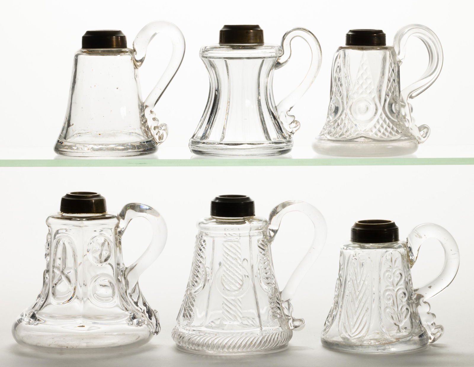 ASSORTED FLINT EAPG WHALE OIL / FLUID FINGER LAMPS, LOT OF SIX,: ASSORTED FLINT EAPG WHALE OIL / FLUID FINGER LAMPS, LOT OF SIX,colorless lead glass,including a Star and Punty, a Cable with Ring, and a Bull's Eye and Sawtooth, each having a brass collar.Various mak