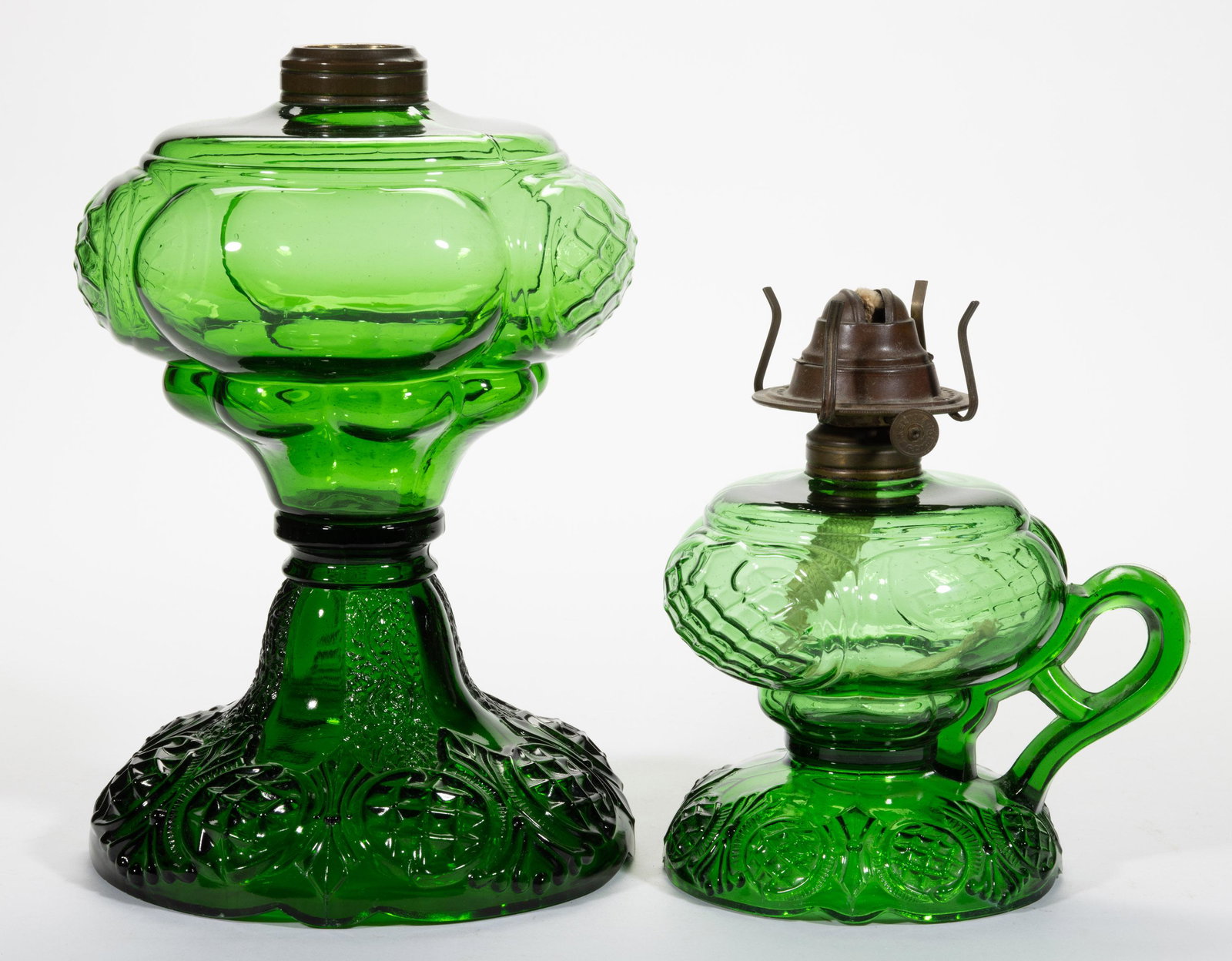 PRINCE EDWARD KEROSENE LAMPS, LOT OF TWO,: PRINCE EDWARD KEROSENE LAMPS, LOT OF TWO,green,comprising a massive size and a footed finger lamp, each having a period collar. Finger lamp fitted with a period slip burner.Maker unverified.Late 19th/