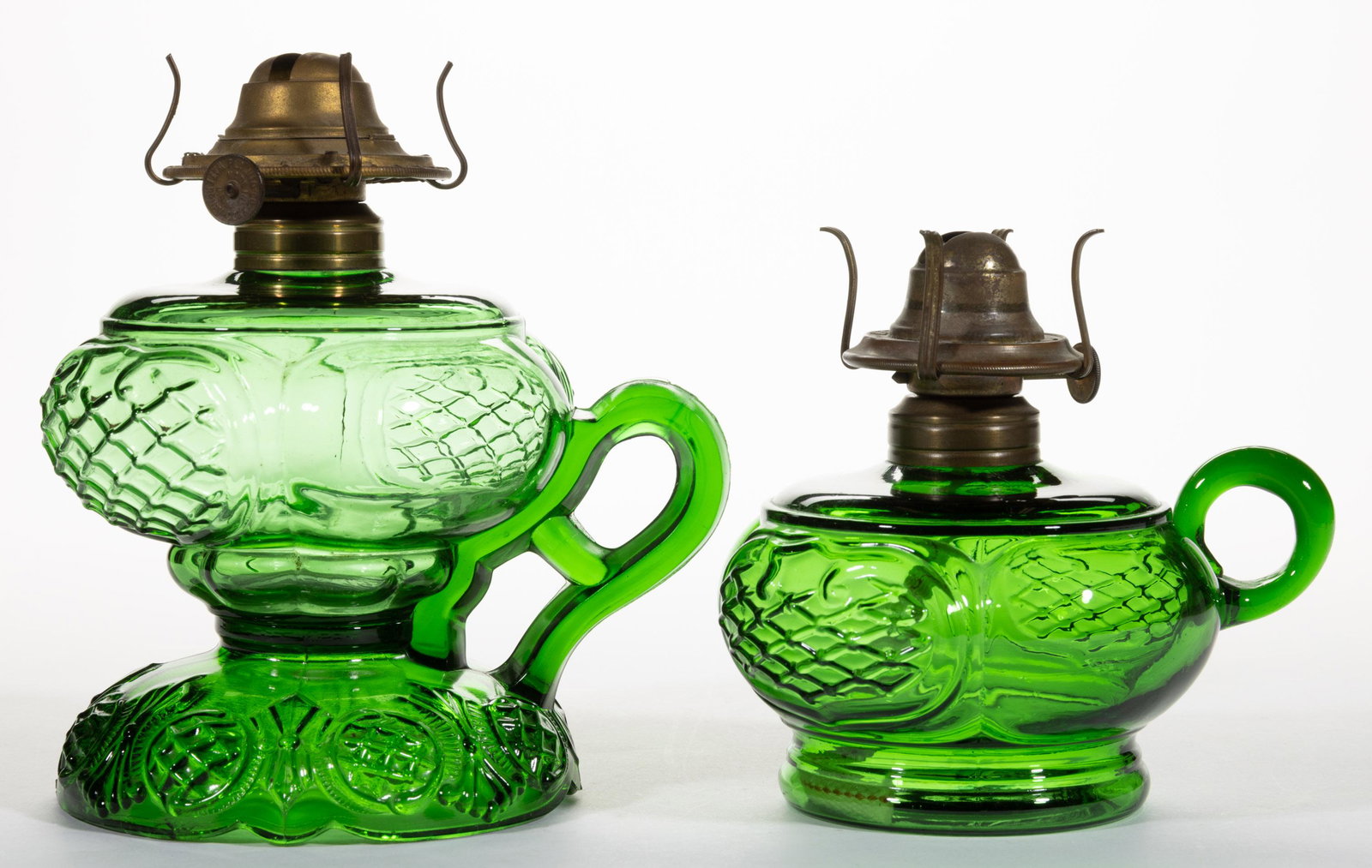 PRINCE EDWARD KEROSENE FINGER LAMPS, LOT OF TWO,: PRINCE EDWARD KEROSENE FINGER LAMPS, LOT OF TWO,green,including a footed example, each having a period No. 1 Taplin-Brown collar. Each fitted with a period slip burner.Maker unverified.Late 19th/early