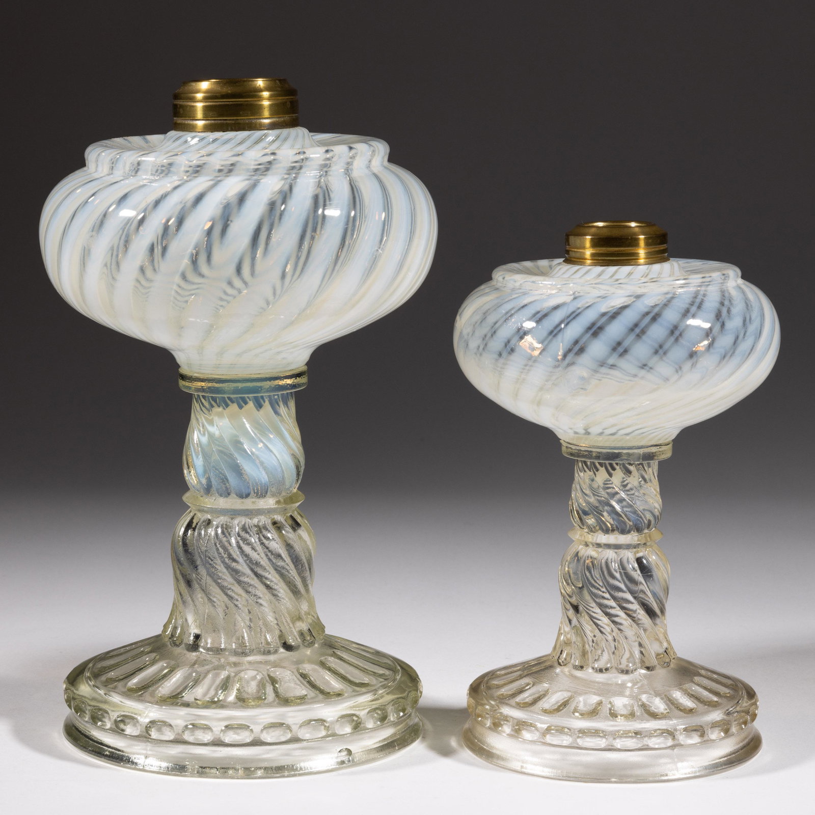 NICKEL PLATE NO. 50 / BANBURY KEROSENE STAND LAMPS, LOT OF TWO,: NICKEL PLATE NO. 50 / BANBURY KEROSENE STAND LAMPS, LOT OF TWO,colorless opalescent,each having a period brass collar.Nickel Plate Glass Co.Circa 1888.7 1/2 and 9 1/4" H. Literature: Thuro- Oil Lamps 