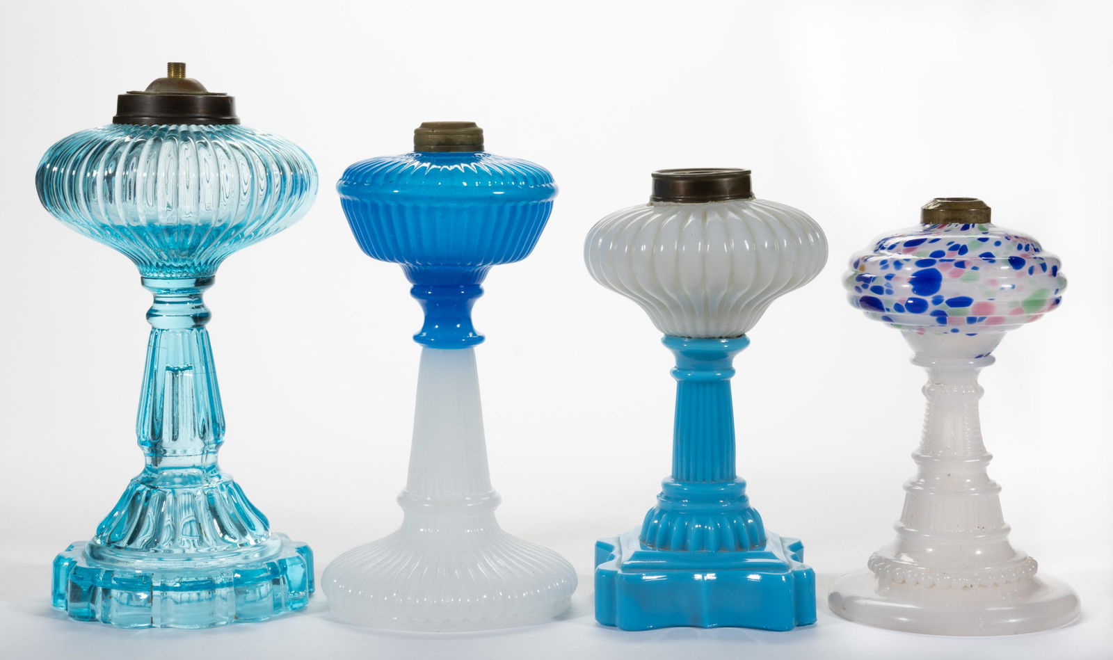 ASSORTED OPAQUE RIBBED GLASS KEROSENE STAND LAMPS, LOT OF THREE,: ASSORTED OPAQUE RIBBED GLASS KEROSENE STAND LAMPS, LOT OF THREE, comprising a starch blue over alabaster/clambroth, an opaque white over powder blue, and a alabaster/clambroth example with multi-color