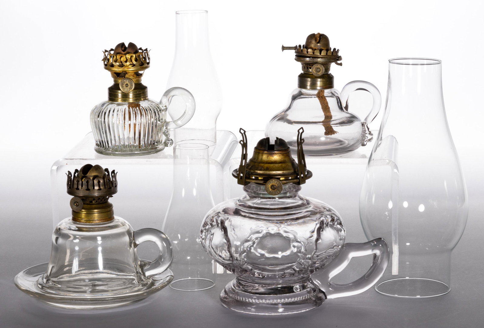 ASSORTED PATTERN FINGER LAMPS, LOT OF FOUR: ASSORTED PATTERN FINGER LAMPS, LOT OF FOUR,colorless, comprising two miniature examples, a Smith I, fig. 34 and a Smith II, fig. 116 ribbed patterned example; a saucer-base example and a Ruffled Bulls