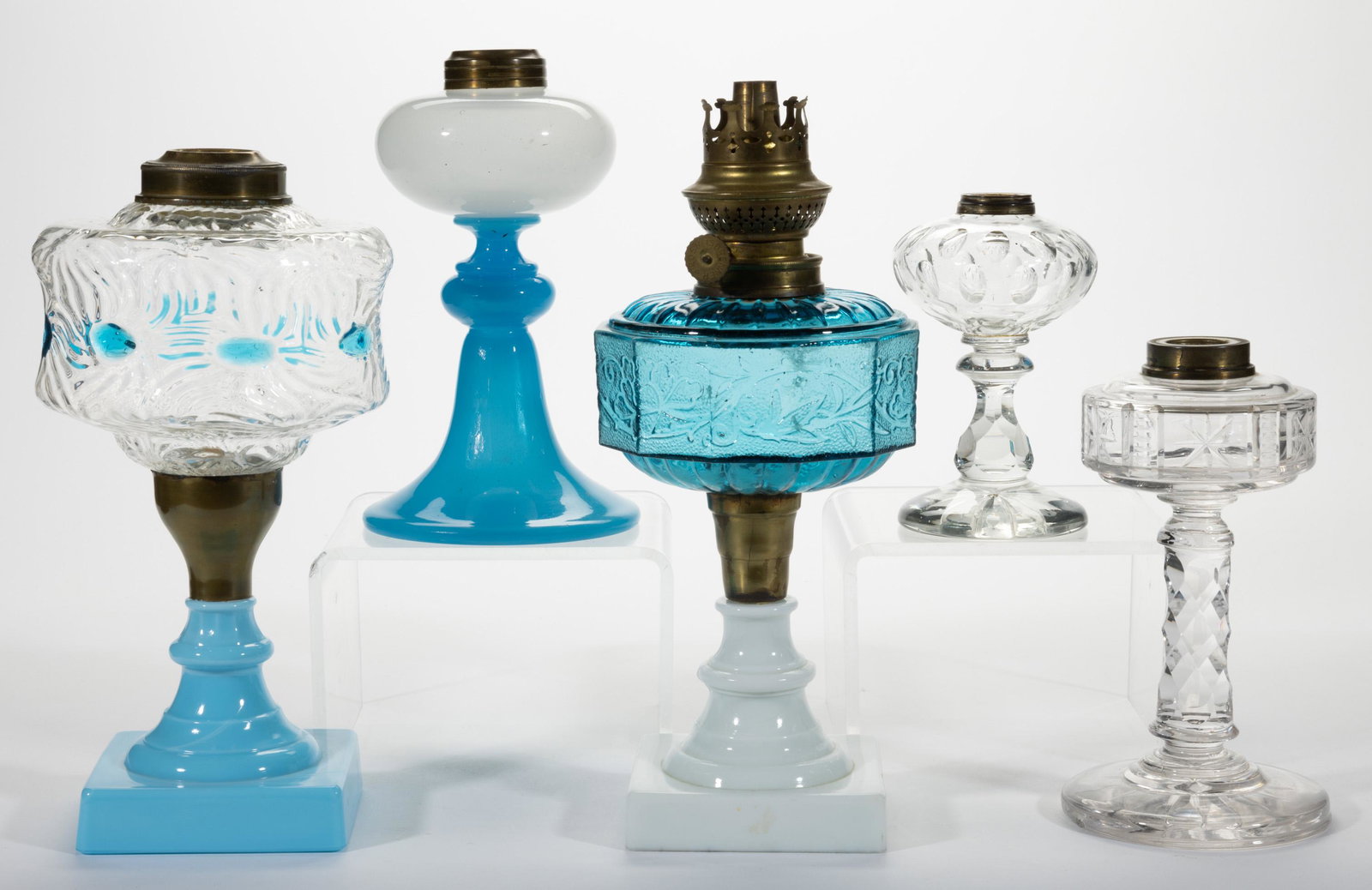 ASSORTED GLASS KEROSENE STAND LAMPS, LOT OF FIVE,: ASSORTED GLASS KEROSENE STAND LAMPS, LOT OF FIVE,various colors,including two cut examples with one having an Ainslie Block pattern, an opaline with white above blue, and an Optic pattern with spaced