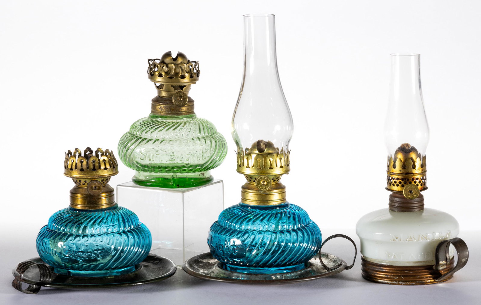 ASSORTED PATTERN MINIATURE LAMPS, LOT OF FOUR: ASSORTED PATTERN MINIATURE LAMPS, LOT OF FOUR,blue, green, and opaque white,comprising three Sunlight/Smith I, fig. 92 examples, including two examples with a nickel-plated saucer base and ring handle