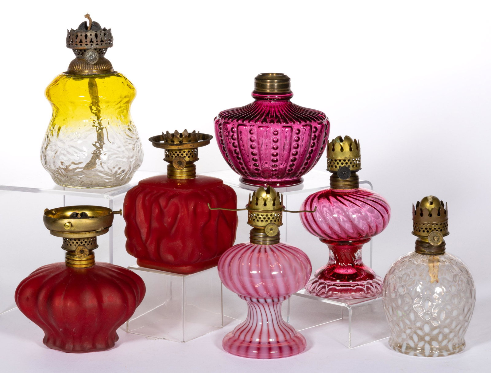 ASSORTED MINIATURE LAMP FONTS, LOT OF SEVEN: ASSORTED MINIATURE LAMP FONTS, LOT OF SEVEN,cased cranberry, cranberry and colorless opalescent and lemon-yellow to colorless,comprising two Smith I, fig. 503 examples, including a swirl opalescent an