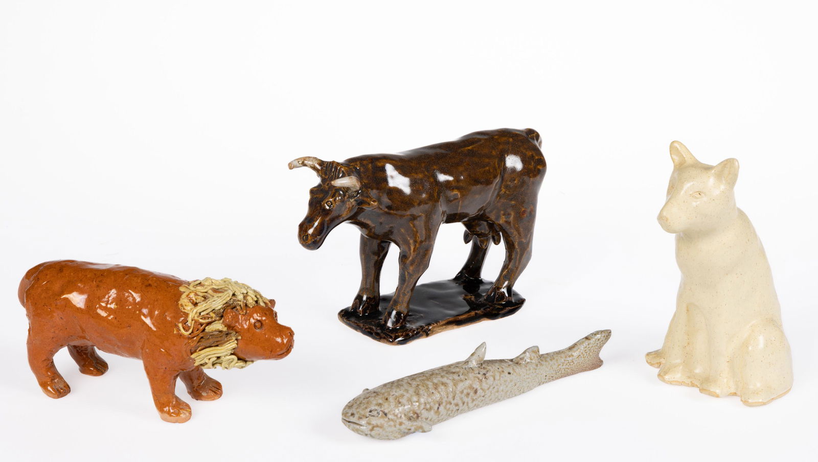 SIGNED CHARLES MOORE (1935-2007), NORTH CAROLINA POTTERY ANIMAL FIGURES, LOT OF FOUR: SIGNED CHARLES MOORE, NORTH CAROLINA POTTERY ANIMAL FIGURES, LOT OF FOUR, comprising a yellow-glazed sitting cat with tail resting on back, a salt-glazed catfish, a brown-glazed standing horned cow on