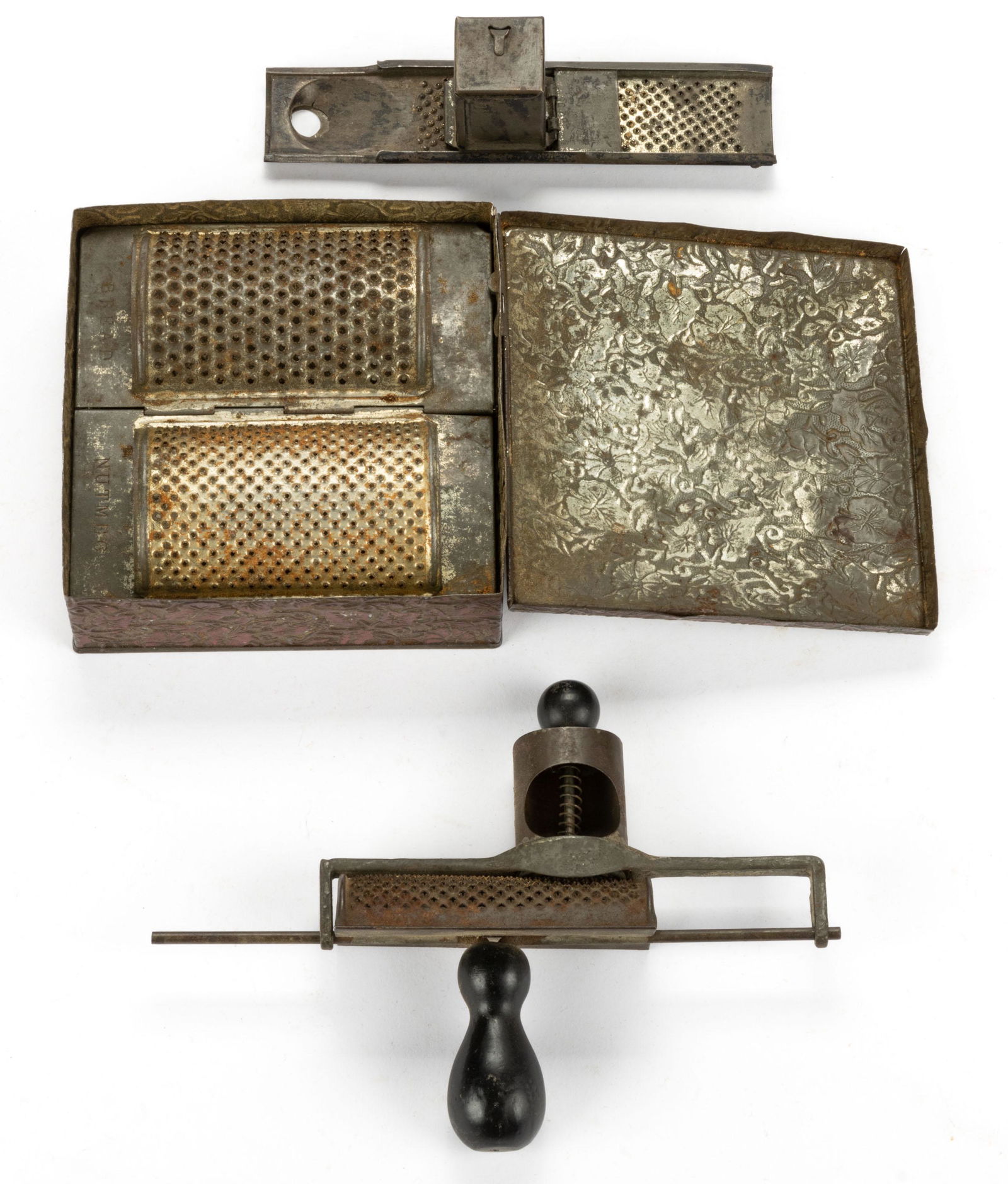 ASSORTED SHEET-IRON NUTMEG / SPICE GRATERS, LOT OF THREE: ASSORTED SHEET-IRON NUTMEG / SPICE GRATERS, LOT OF THREE,comprising Boye, Edgar Mfg., and Bryand and May examples in original box tin with contents.19th/early 20th century.Box 1/2" H. Provenance: From
