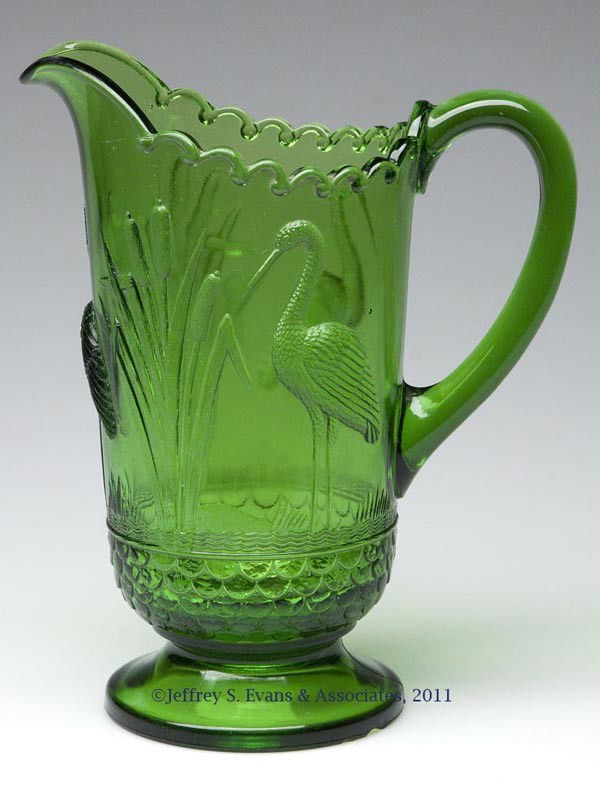 STORK AND RUSHES / NO 6404 WATER PITCHER: STORK AND RUSHES / NO 6404 WATER PITCHER, green. U S Glass Co. Late 19th/early 20th century. 9 3/8" HOA, 4 1/4" D foot.Literature: Heacock V, p. 169.Provenance: Collection of Tom Heintzman.