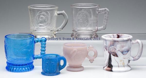CHILDREN'S PRESSED GLASS MUGS, LOT OF SIX: CHILDREN'S PRESSED GLASS MUGS, LOT OF SIX, including a blue Bird on a Branch, a pink alabaster Swan with Ring Handle, and a blue opalescent Beads In Relief with smoky striations. Fourth quarter 19th c