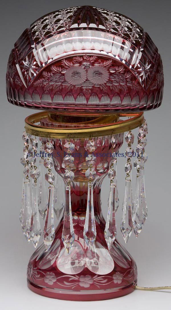 CUT OVERLAY LEAD CRYSTAL ELECTRIC LAMP: CUT OVERLAY LEAD CRYSTAL ELECTRIC LAMP, red to colorless, mushroom shade with floral, cane and ray cuttings, hung with prisms. Second half 20th century. 17 1/2" HOA. Provenance: Collection of Bertram 