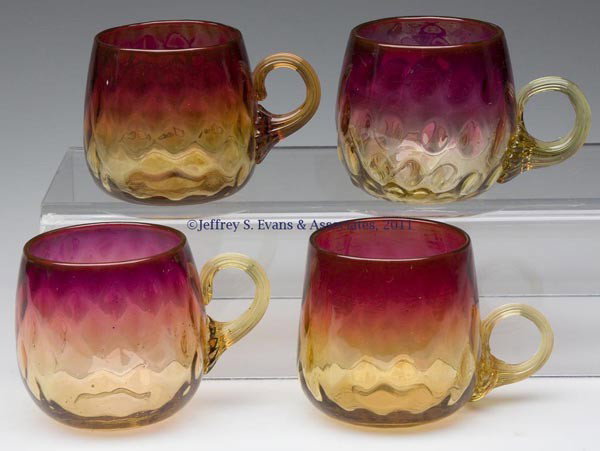 AMBERINA DIAMOND-OPTIC PUNCH CUPS, LOT OF FOUR: AMBERINA DIAMOND-OPTIC PUNCH CUPS, LOT OF FOUR, each with an amber applied reeded handle and polished pontil mark. W. L. Libbey & Sons and others. Late 19th/early 20th century. 2 1/2" H, 2 1/4" D rim.
