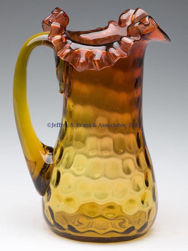 AMBERINA INVERTED THUMBPRINT MILK PITCHER: AMBERINA INVERTED THUMBPRINT MILK PITCHER, crimped tripartite rim, applied handle and polished pontil mark. Fourth quarter 19th century. 7 1/4" HOA. Provenance: Collection of Tom Heintzman.