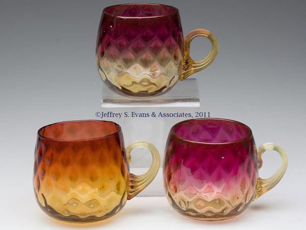 AMBERINA DIAMOND-OPTIC PUNCH CUPS, LOT OF THREE: AMBERINA DIAMOND-OPTIC PUNCH CUPS, LOT OF THREE, each with an amber applied reeded handle and polished pontil mark. Mt. Washington Glass Co. and others. Late 19th/early 20th century. 2 1/2" H, 2 1/4" 