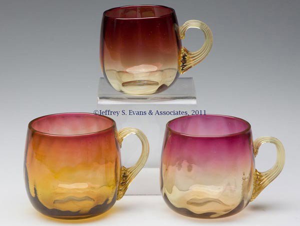 AMBERINA OPTIC PATTERN PUNCH CUPS, LOT OF THREE: AMBERINA OPTIC PATTERN PUNCH CUPS, LOT OF THREE, various patterns, each with an amber applied reeded handle and polished pontil mark. Mt. Washington Glass Co. and others. Late 19th/early 20th century.