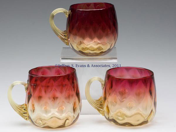 AMBERINA VARIOUS DIAMOND-OPTIC PUNCH CUPS, LOT OF : AMBERINA VARIOUS DIAMOND-OPTIC PUNCH CUPS, LOT OF THREE, each with an amber applied reeded handle and polished pontil mark. Mt. Washington Glass Co. and possibly others. Late 19th/early 20th century. 