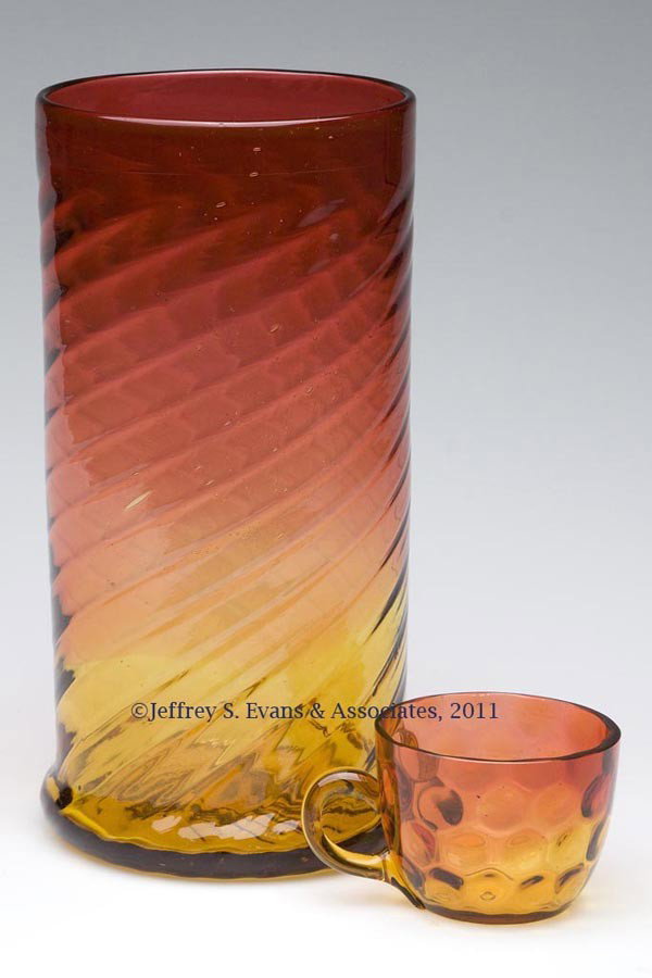 AMBERINA OPTIC PATTERN ARTICLES, LOT OF TWO: AMBERINA OPTIC PATTERN ARTICLES, LOT OF TWO, comprising a large swirled rib vase with polished pontil mark, and an Inverted Thumbprint punch cup with amber applied handle. Late 19th/early 20th century