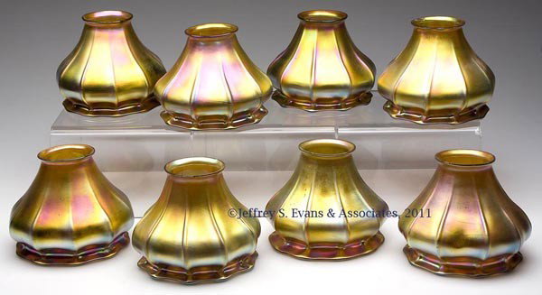 STEUBEN GOLD AURENE RIB-OPTIC SHADES, SET OF EIGHT: STEUBEN GOLD AURENE RIB-OPTIC SHADES, SET OF EIGHT, each with 10 ribs, probably shape 832. Attributed to the Steuben Glass Works, Corning, NY. First quarter 20th century. 4" and 4 1/4" H, 2 1/4" fitte
