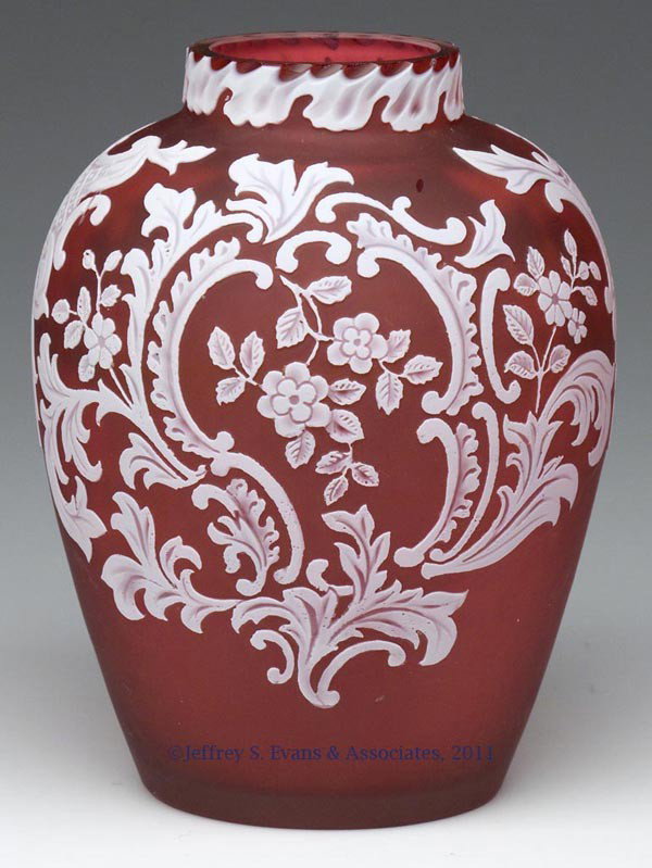 ENGLISH CARVED CAMEO GLASS VASE: ENGLISH CARVED CAMEO GLASS VASE, white over ruby with acid finish, floral and cartouche decorations, factory polished rim, pontil mark and table ring. Fourth quarter 19th century. 5 3/4" H. Provenance
