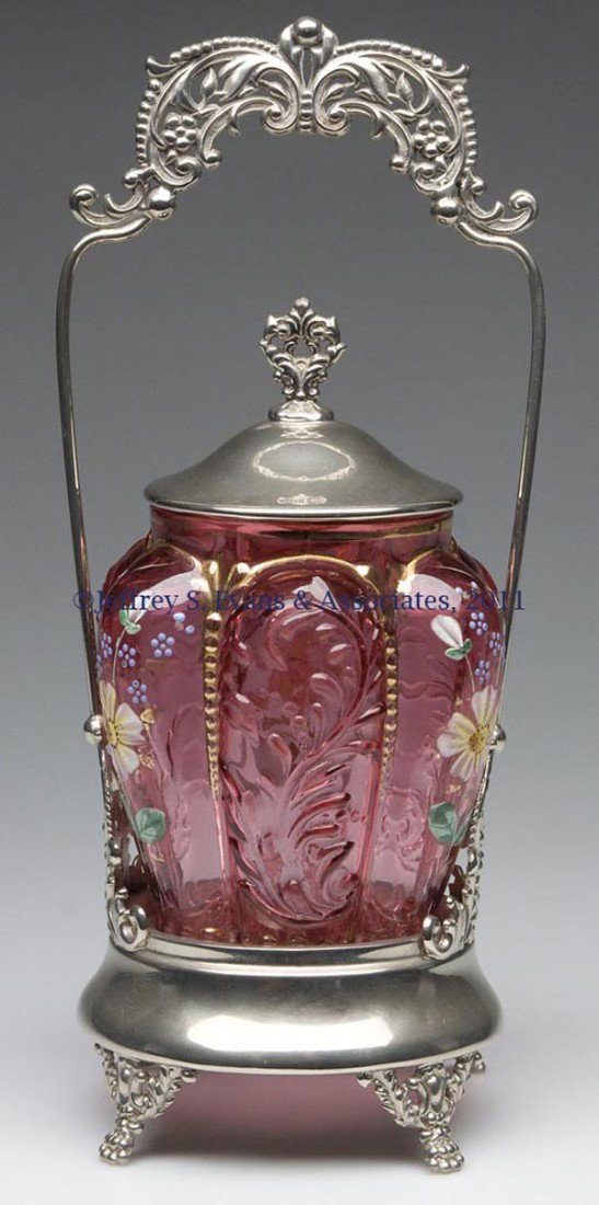 PANELED SPRIG PICKLE CASTER: PANELED SPRIG PICKLE CASTER, cranberry with polychrome floral and gilt decoration, fitted in a Colonial Silver Co. quadruple-plate frame with an illegible number, and cover, lacking tongs. Rim of jar 