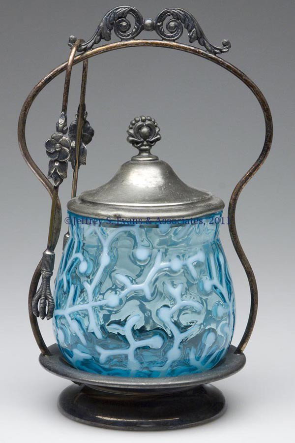 SEAWEED / CORAL REEF PICKLE CASTER: SEAWEED / CORAL REEF PICKLE CASTER, blue opalescent, fitted in a Van Bergh Silver Plate Co. quadruple-plate frame, marked "2210", with cover and tongs. Rim of jar polished during manufacturing process