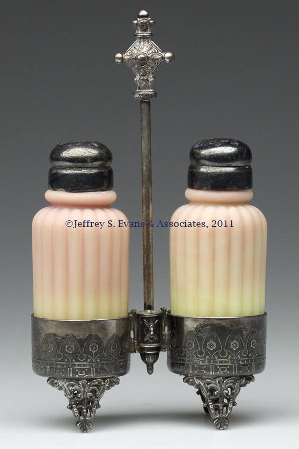 MT. WASHINGTON BURMESE PLUSH RIBBED SALT AND PEPPE: MT. WASHINGTON BURMESE PLUSH RIBBED SALT AND PEPPER SHAKERS, fitted in a Barbour Bros. Silver Co. silver-plate stand, two-part period lids. Mt. Washington Glass Co. Fourth quarter 19th century. 7" HOA