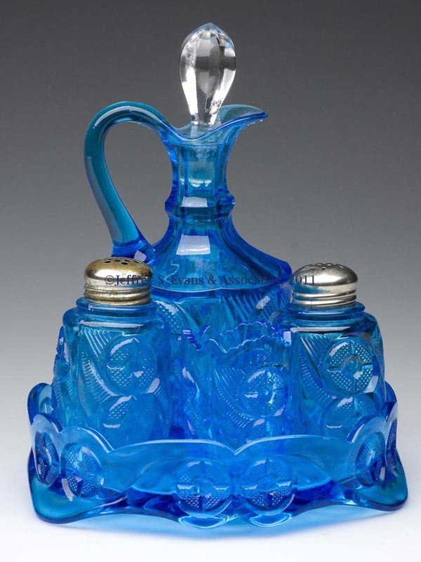 DOUBLE CIRCLE FIVE-PIECE CRUET SET: DOUBLE CIRCLE FIVE-PIECE CRUET SET, sapphire blue, comprising a cruet with appropriate colorless stopper, pair of salt and pepper shakers, and a toothpick holder on a tray raised on three feet. Jeffer