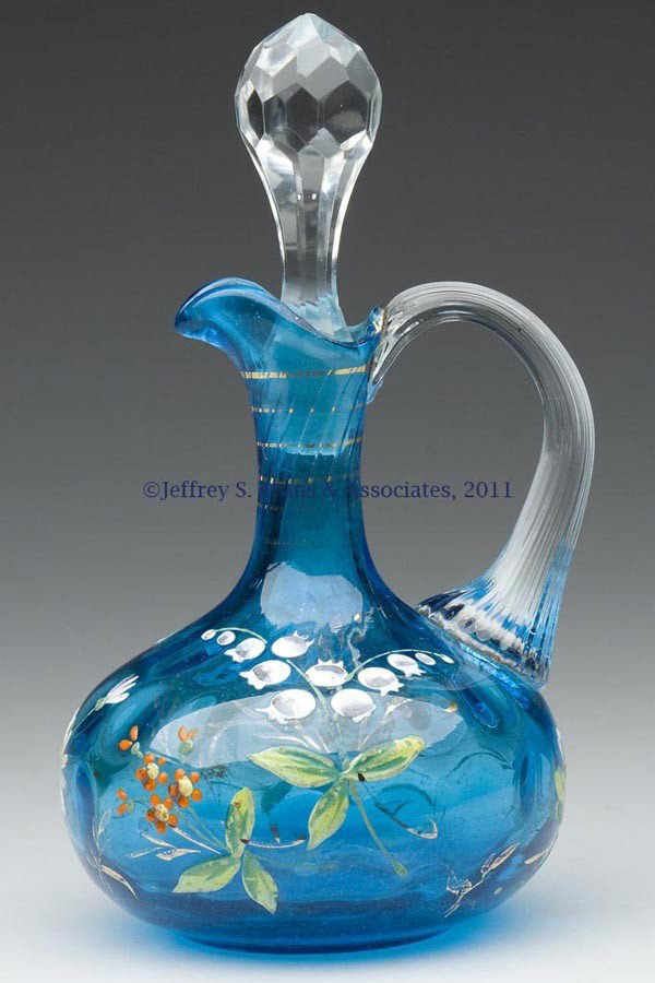 INVERTED THUMBPRINT CRUET: INVERTED THUMBPRINT CRUET, blue with full-round polychrome floral and gilt decoration, with a colorless applied reeded handle and cut-facet stopper, polished pontil mark. Late 19th/early 20th century.