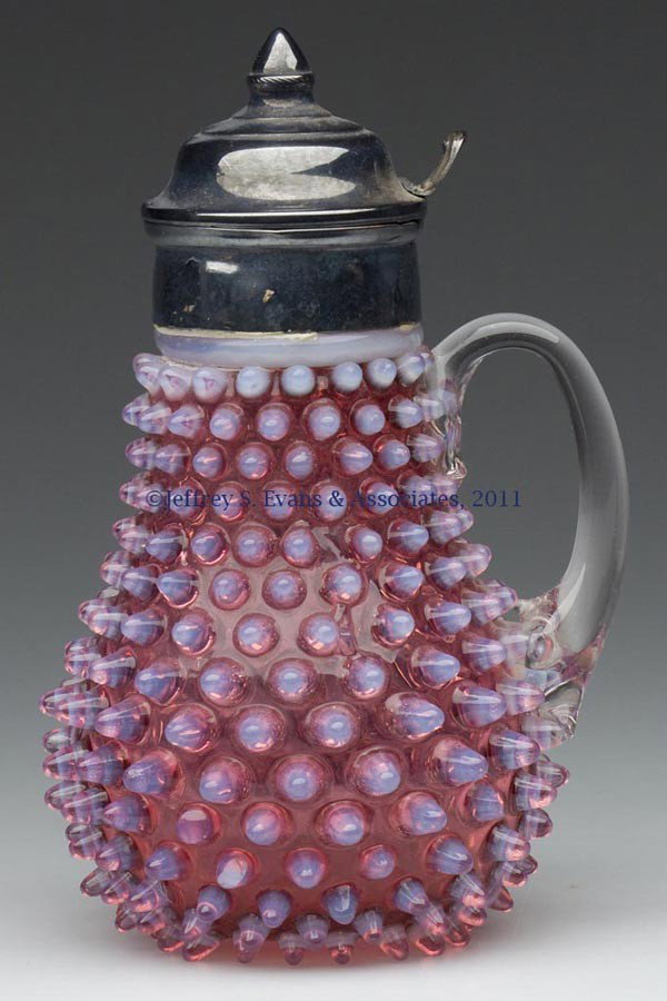 HOBBS' NO. 323 DEW DROP / HOBBS' HOBNAIL SYRUP PIT: HOBBS' NO. 323 DEW DROP / HOBBS' HOBNAIL SYRUP PITCHER, Ruby opalescent/cranberry opalescent, colorless applied handle, polished pontil mark, period lid. Hobbs, Brockunier & Co. Fourth quarter 19th ce