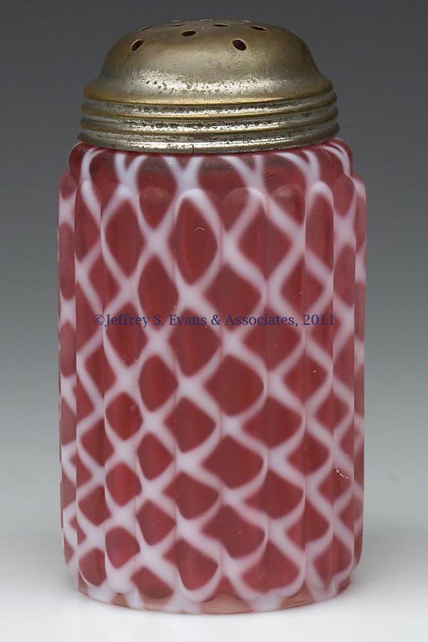 RIBBED OPAL LATTICE SUGAR SHAKER: RIBBED OPAL LATTICE SUGAR SHAKER, cranberry opalescent with satin finish, period lid. Late 19th/early 20th century. 4 1/2" HOA. Provenance: Personal collection of Judith (Judy) Cronin, Orleans, MA.