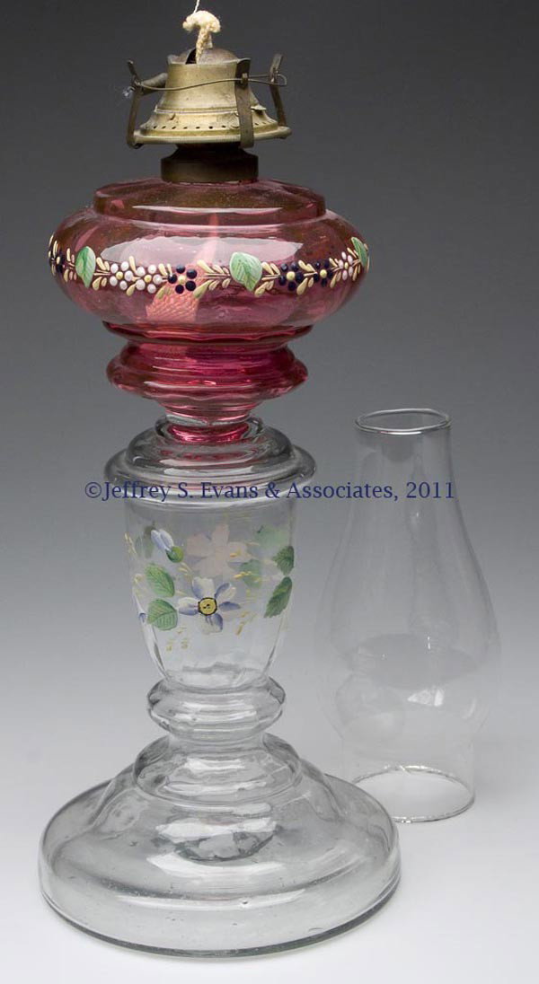 BLOWN PANEL-OPTIC STAND LAMP: BLOWN PANEL-OPTIC STAND LAMP, cranberry font, colorless base, each with floral polychrome decoration, rough pontil mark with center hole, period No. 1 collar and slip burner, non-period chimney. Late 