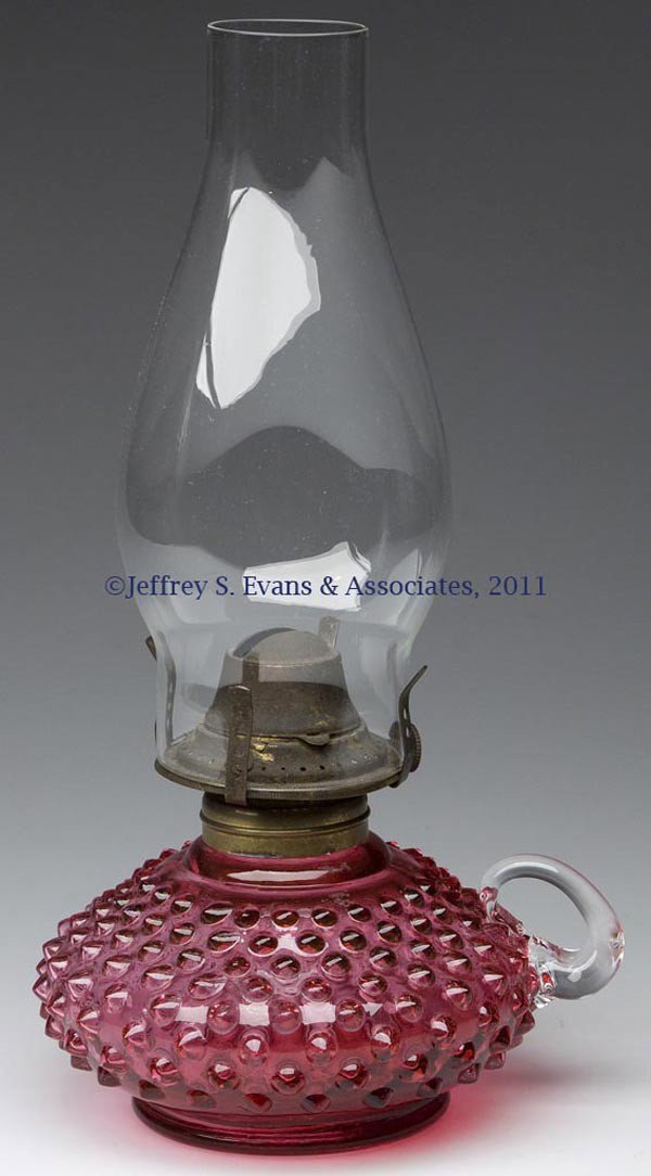 FENTON'S HOBNAIL "COURTING" FINGER LAMP: FENTON'S HOBNAIL "COURTING" FINGER LAMP, Ruby/cranberry, colorless applied handle, period No. 1 collar, slip burner, and chimney. Fenton Glass Co. Second half 20th century. 3 1/2" H to top of collar, 