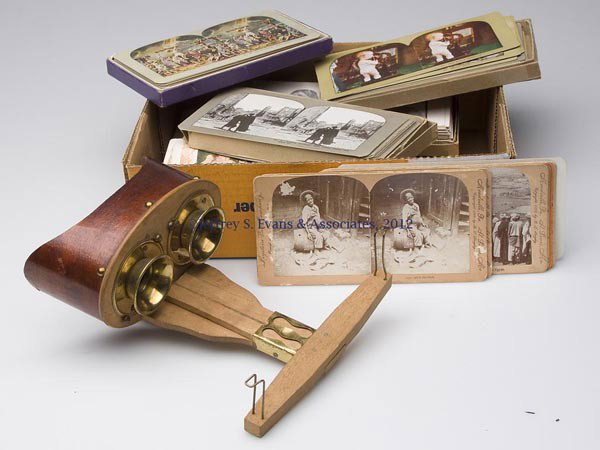 HAND-HELD STEREOVIEWER AND CARDS: HAND-HELD STEREOVIEWER AND CARDS, viewer with brass mounts and marked "THE STEREO-GRAPHOSCOPE" and with patent dates, along with a large lot of cards, mostly printed, many in sets, subjects include Sa