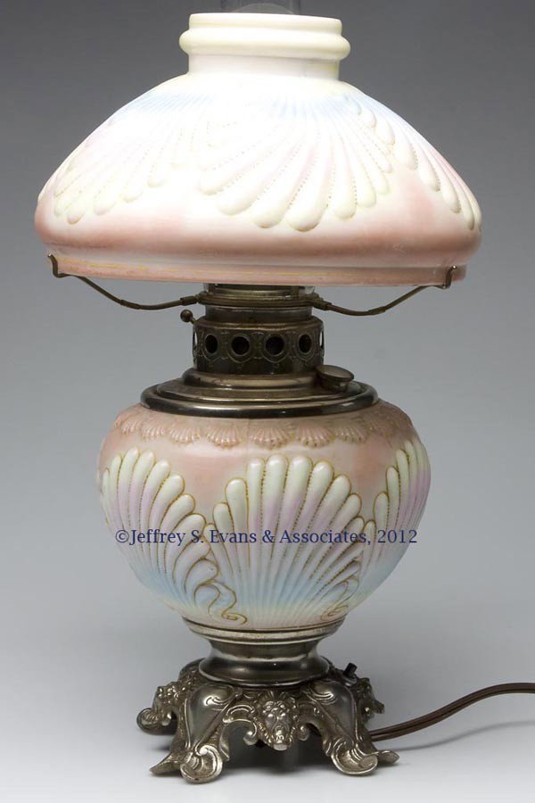 VICTORIAN DECORATED PARLOR LAMP: VICTORIAN DECORATED PARLOR LAMP, opaque white with pink, blue, and yellow shading, embossed shell pattern, cast iron nickel-plated base with lion's heads, embossed "200" to underside, drop-in font, el