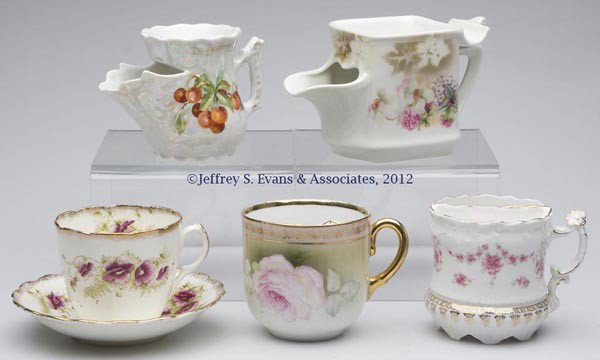 ASSORTED CHINA SHAVING MUGS AND MUSTACHE CUPS, LOT: ASSORTED CHINA SHAVING MUGS AND MUSTACHE CUPS, LOT OF FIVE, comprising two scuttle mugs, one shaving mug and two mustache cups, one with saucer, four marked for Germany and one for England. Late 19th/