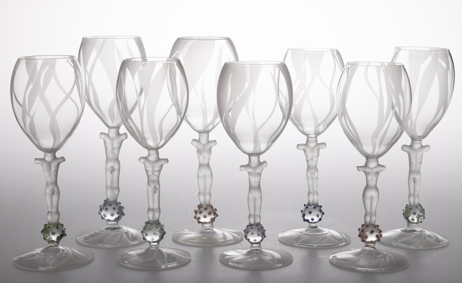 FIGURAL STEM ART GLASS GOBLETS, LOT OF EIGHT, frosted and colorless, comprising four nude male and: FIGURAL STEM ART GLASS GOBLETS, LOT OF EIGHT, frosted and colorless, comprising four nude male and four nude femal examples,frosted decoration to the bowls. Maker unverified. 20th century. 9"