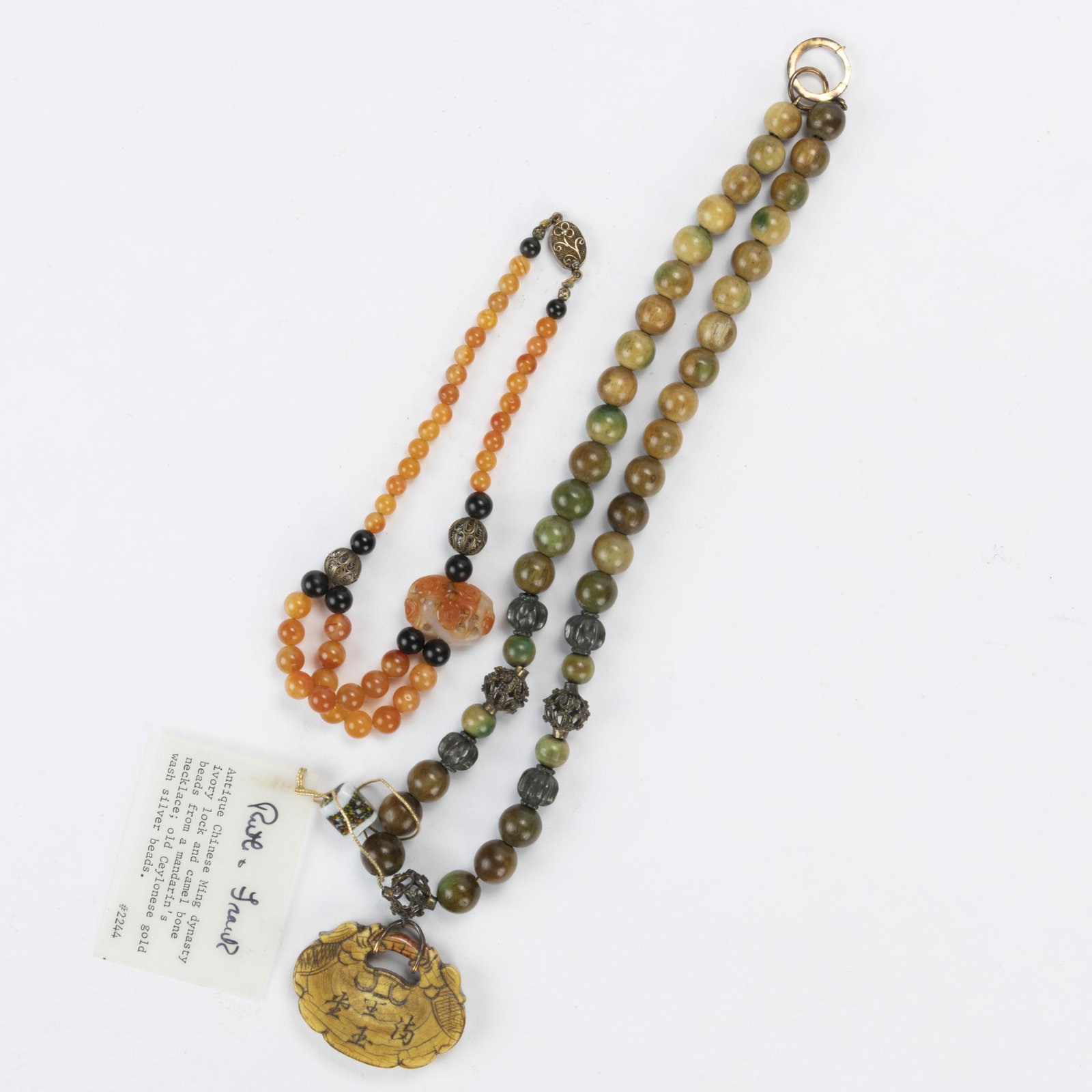 RUTH O. FRANK (AMERICAN, 1921-2021) BEADED NECKLACE, featuring green-hue bone beads and : RUTH O. FRANK (AMERICAN, 1921-2021) BEADED NECKLACE, featuring green-hue bone beads and silver-like metal beads on a silver-toned foxtail chain with a carved bone pendant and a large spring-ring 