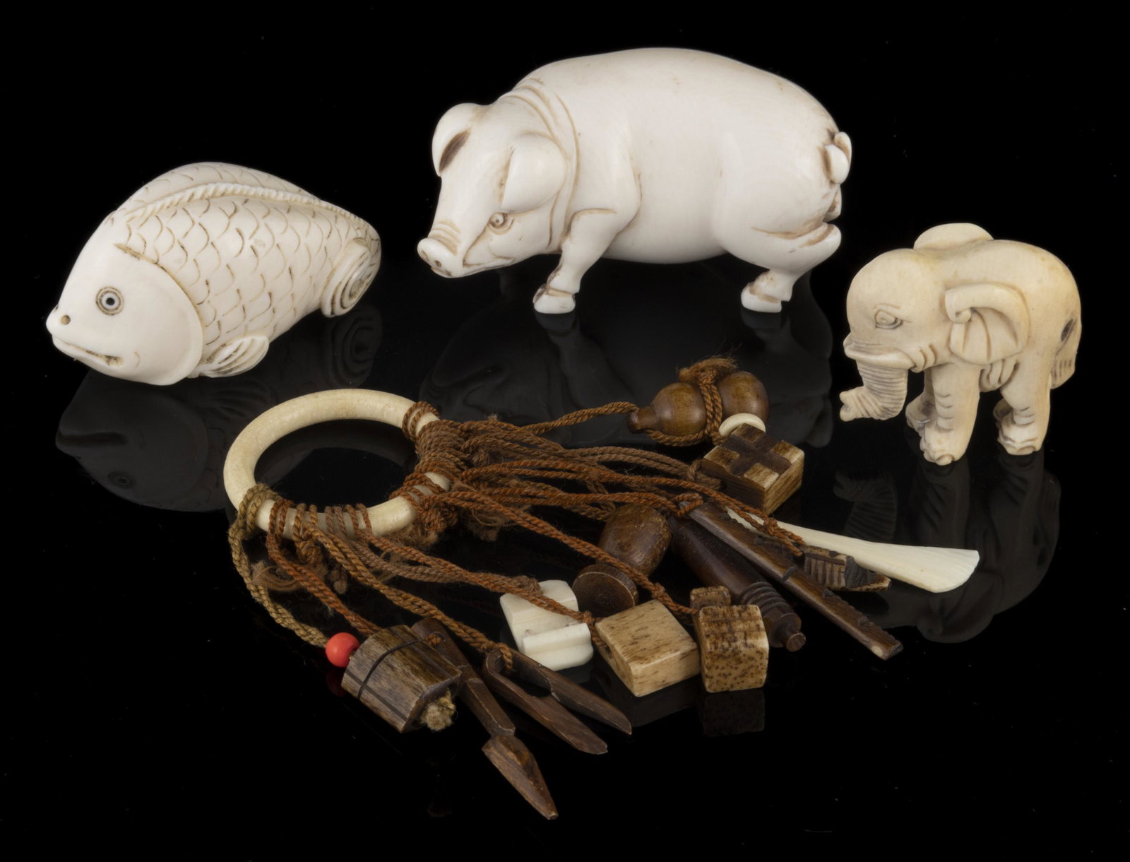 CHINESE / JAPANESE CARVED FIGURAL NETSUKE AND MINIATURE OBJECTS, LOT OF FOUR, comprising three: CHINESE / JAPANESE CARVED FIGURAL NETSUKE AND MINIATURE OBJECTS, LOT OF FOUR, comprising three carved bone figural netsuke with each being signed consisting of a pig, a fish, and an elephant, and