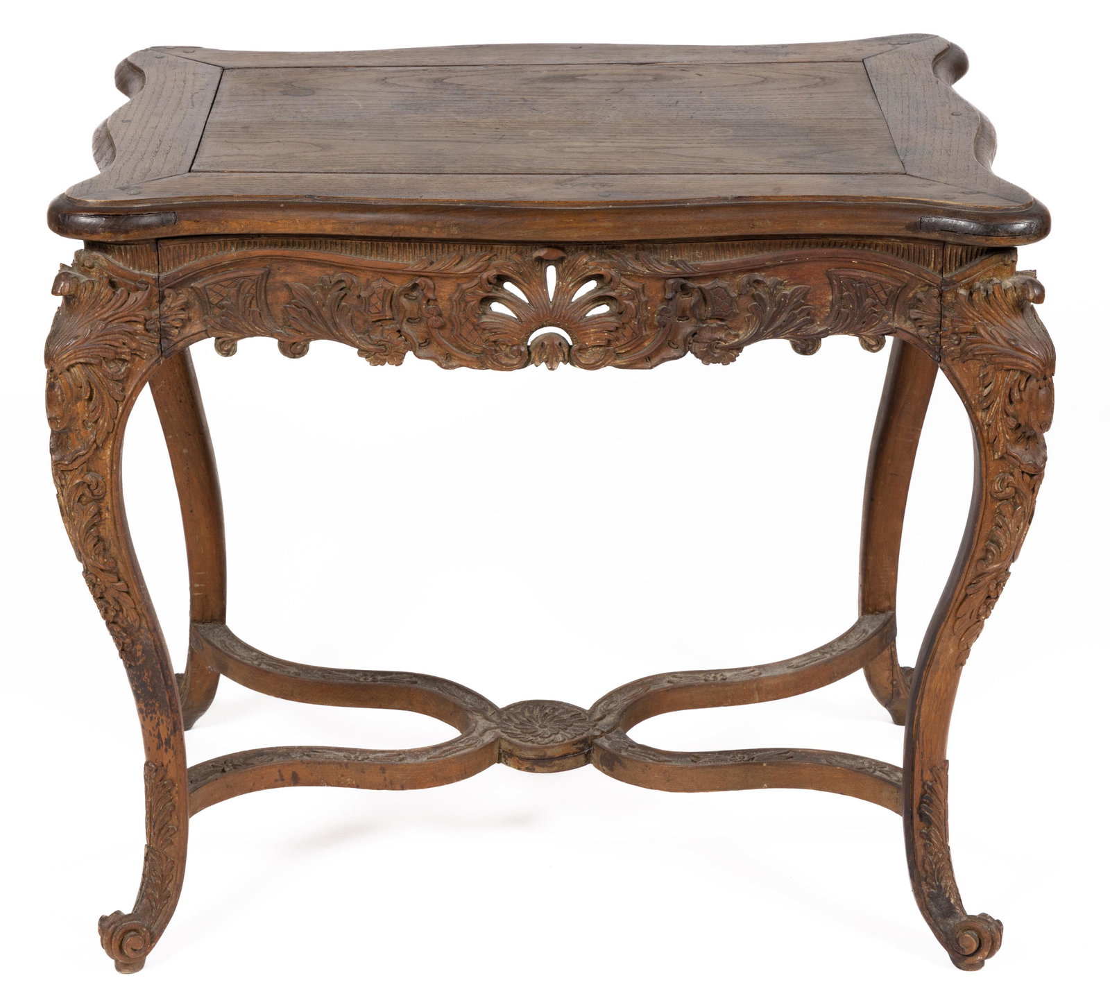 FRENCH LOUIS XV CARVED FRUITWOOD CENTER TABLE: FRENCH LOUIS XV CARVED FRUITWOOD CENTER TABLE, in the Rococo style, featuring shaped top, conforming apron, and cabriole legs joined with shaped stretcher, richly carved foliate ornamentation througho