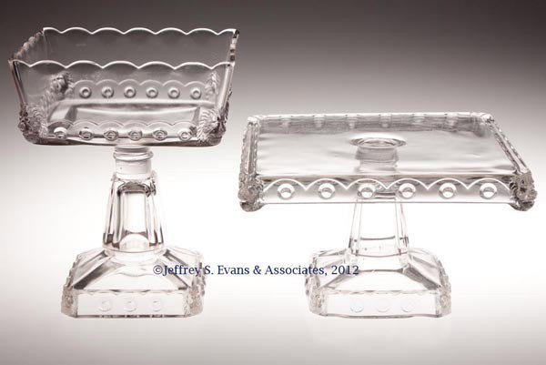 ATLANTA / SQUARE LION TABLE ARTICLES, LOT OF TWO: ATLANTA / SQUARE LION TABLE ARTICLES, LOT OF TWO, colorless, comprising a cake stand and a true open compote. Fostoria Glass Co. Late 19th/early 20th century. 5 1/2" H, 9" SQ, and 8 3/4" H, 7" SQ. Pro