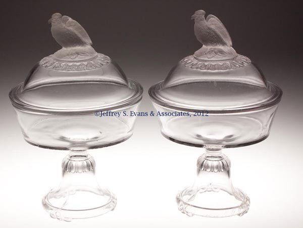 FROSTED EAGLE / OLD ABE PAIR OF COVERED COMPOTES: FROSTED EAGLE / OLD ABE PAIR OF COVERED COMPOTES, colorless with frosted finials, each on high standard. Fourth quarter 19th century. 13" HOA, 8" D. Provenance: Jerry Lynn Wood estate, Dequincy, LA.