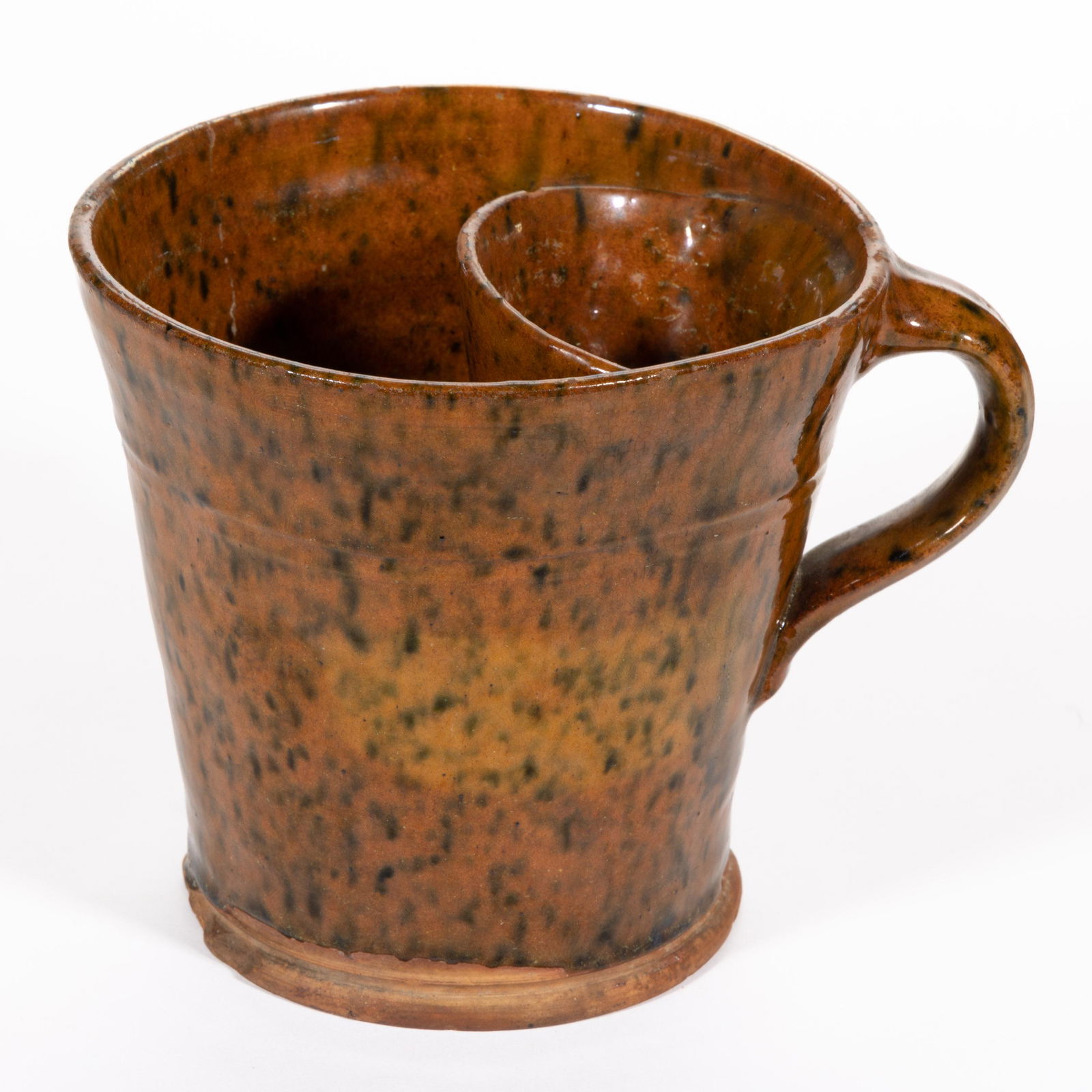 AMERICAN EARTHENWARE / REDWARE SHAVING MUG: AMERICAN EARTHENWARE / REDWARE SHAVING MUG, lead- and copper-glazed, tapered form with interior well for brush, an incised shoulder ring, an applied grooved strap handle, and beaded foot. Possibly Win