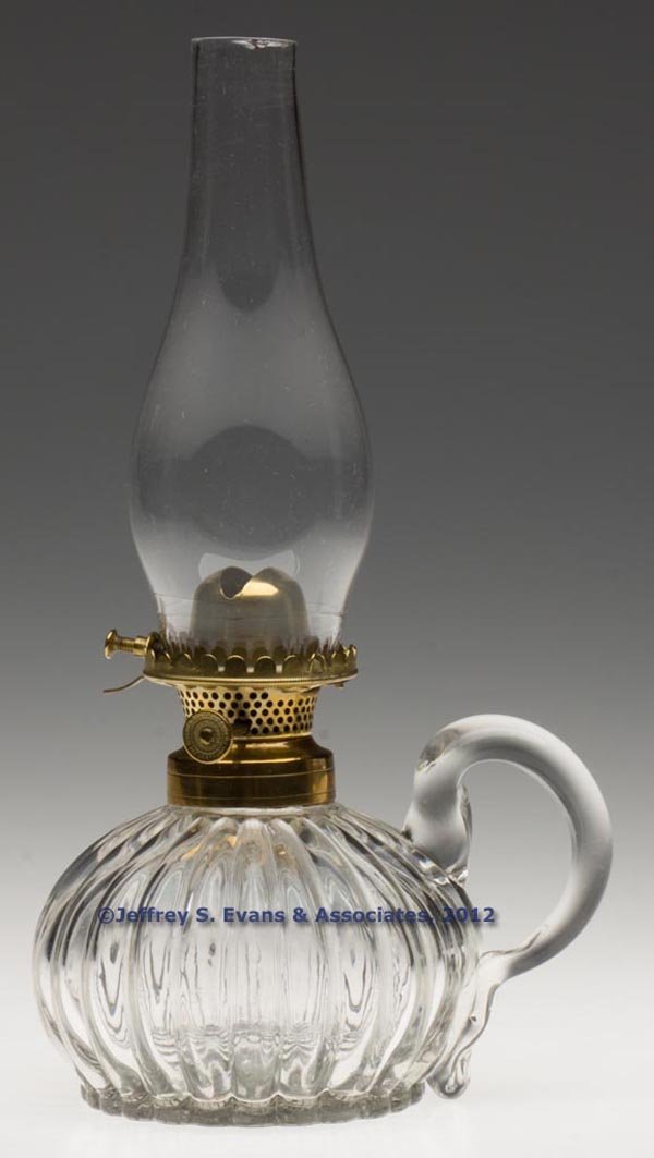 HOLMES, BOOTH & HAYDENS NO. 0 HINGED LIP BURNER: HOLMES, BOOTH & HAYDENS NO. 0 HINGED LIP BURNER, thumbwheel marked "HOLMES BOOTH & HAYDEN'S PAT. JANY. 24/60 / PAT SEPR 16/62 MARCH 3/63", period lip chimney. Fitted on a colorless Mellon finger lamp,