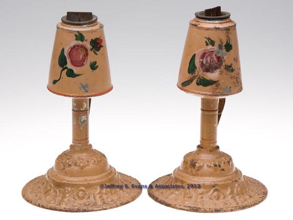 DECORATED SHEET AND CAST IRON LARD OIL LAMPS, PAIR: DECORATED SHEET AND CAST IRON LARD OIL LAMPS, PAIR, peach ground with polychrome floral decoration, conical-form font with sleeves for shade, wide flat wick, burners marked "PERRYS PATENT", strap ring