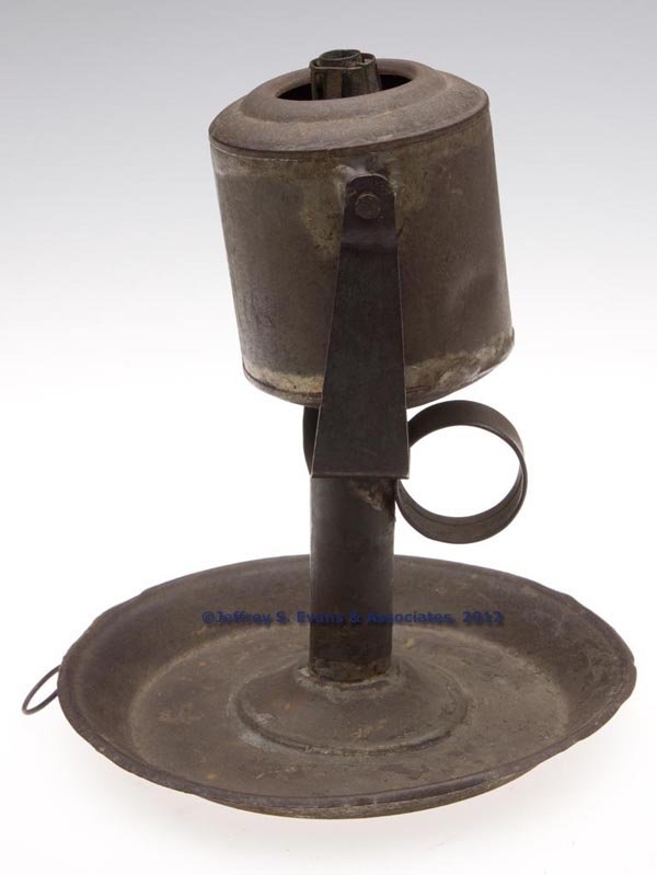 SHEET IRON ARGAND-TYPE LARD LAMP: SHEET IRON ARGAND-TYPE LARD LAMP, cylinder form with strap ring handle, gimbal mounting and a saucer base or wall hanging unit, single tube burner with central air chamber. Mid 19th century. 6 7/8" H,
