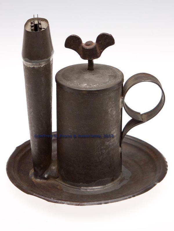 SHEET IRON SMITH & STONESIFER PATENT MECHANICAL LA: SHEET IRON SMITH & STONESIFER PATENT MECHANICAL LARD LAMP, cylinder form with cover, fitted with a wing-nut screw finial and actuated piston which forces lard into the wick tube, saucer base and strap