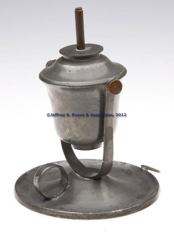 PEWTER FLUID BURNING LAMP: PEWTER FLUID BURNING LAMP, bell-form font with gimbaled mounting, saucer base with underside marked "31", and with ring handle and hanging ring. Fitted with a pewter and brass single-tube burner. 19th