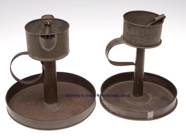 SHEET IRON GREASE / FAT LAMPS ON STANDS, LOT OF TW: SHEET IRON GREASE / FAT LAMPS ON STANDS, LOT OF TWO, each of kettle form with a strap handle and saucer base, one with a single wick support and other example with a double spout fitted with wick supp