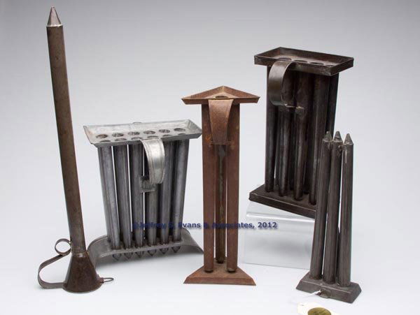 SHEET IRON CANDLE MOLDS, LOT OF FIVE: SHEET IRON CANDLE MOLDS, LOT OF FIVE, comprising a single-tube, two three-tube, one eight-tube and one 2-tube, each with strap handle or handles. 19th and/or 20th century. 11" to 18 1/2" H. Provenance