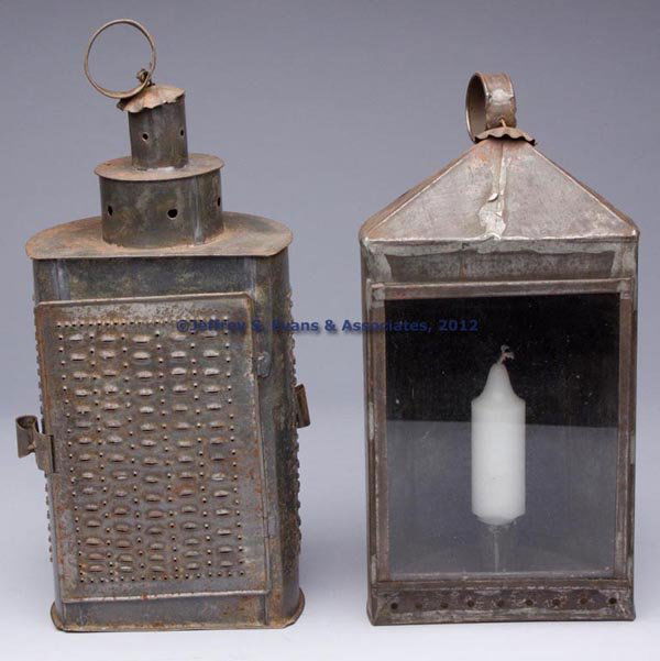 SHEET IRON CANDLE LANTERNS, LOT OF TWO: SHEET IRON CANDLE LANTERNS, LOT OF TWO, each with strap ring handle, comprising a punched and pierced example with double doors including one which conceals a colorless glass pane, remaining example w