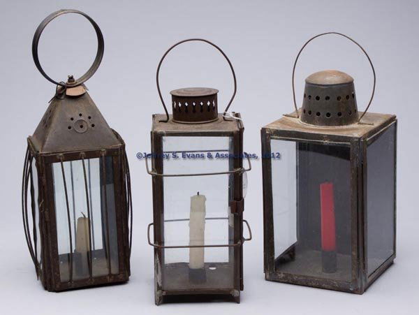 SHEET IRON CANDLE LANTERNS, LOT OF THREE: SHEET IRON CANDLE LANTERNS, LOT OF THREE, square forms with a single socket holders, comprising two examples with colorless glass panes on each side, wire guards and a hinged door, one example with a